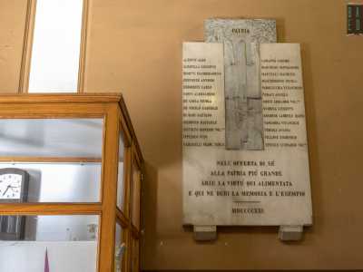 ...superiamo la targa lapidea dello scultore tranese Antonio Bassi, realizzata negli anni 20 a memoria degli studenti caduti nella Prima guerra mondiale...